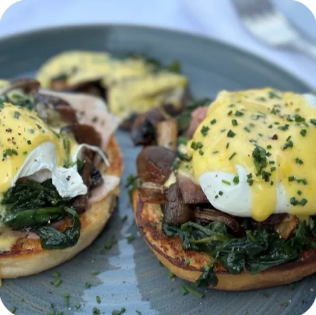 Assiette d'œufs pochés sauce hollandaise servie au café